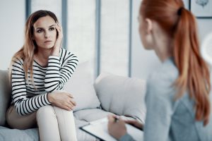 A woman who appears upset while talking to her Indiana therapist rests her head on her hand. Renewed Hope Counseling can offer the support you deserve with couples counseling in Greenwood, IN, family therapy, couples counseling, and more.